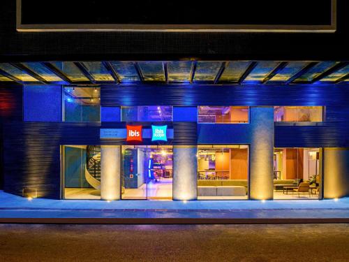 巴拉奈里奥-坎布里乌Ibis Balneario Camboriu的享有带蓝色灯光的建筑的夜景