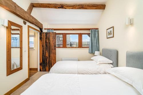 BuckinghamshireMill Cottage的带窗户的客房内的两张床