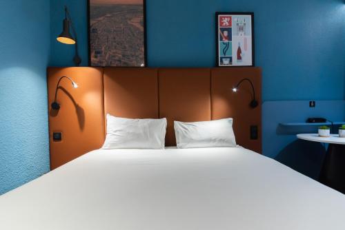达迪利里昂北部宜必思酒店的卧室配有带白色枕头的大床