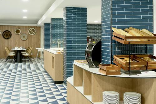 波塔尔斯诺斯Exe Portals Nous的一间铺有蓝色瓷砖的餐厅和一个面包柜台