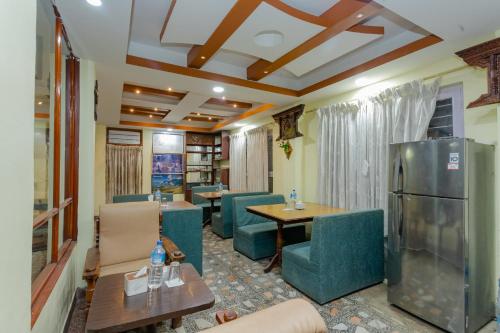 加德满都OYO 811 Hotel New Pokhara Palace的配有桌椅和冰箱的房间