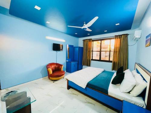 卡拉奇Karachi Inn的蓝色卧室,配有床和椅子