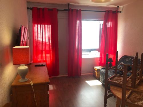 Saint-Aventinplein sud的一间卧室配有红色窗帘、书桌和窗户