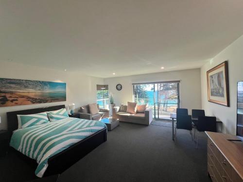 卡尔斯Phillip Island Holiday Apartments的一间卧室设有一张床和一间客厅。