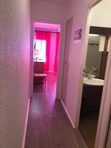 Saint-Aventinplein sud的一个带水槽的走廊和一间带粉红色墙壁的浴室