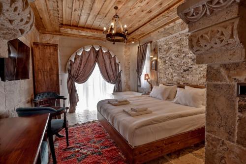 乌奇希萨尔Chiaro Boutique Hotel的一间卧室设有一张大床和一个窗户。