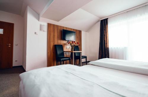 Obernberg am InnPension Baumgartner-Berghof的酒店客房设有两张床和一张桌子。