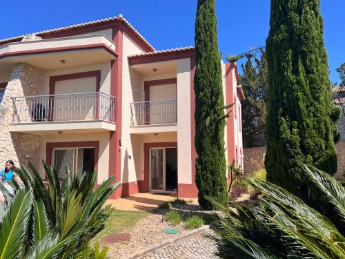 埃斯坦巴Vale da Pinta Golf的前面有树木的粉红色房子