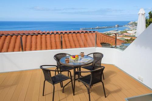 丰沙尔GuestReady - An amazing blue ocean view的海景阳台上的桌椅