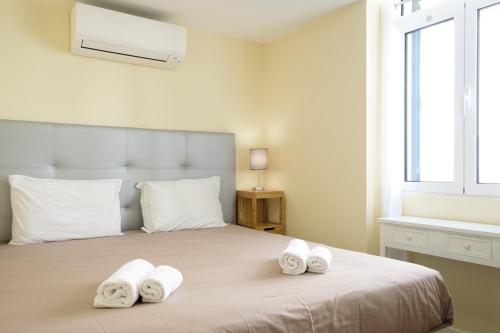 丰沙尔GuestReady - An amazing blue ocean view的一间卧室配有一张大床和毛巾