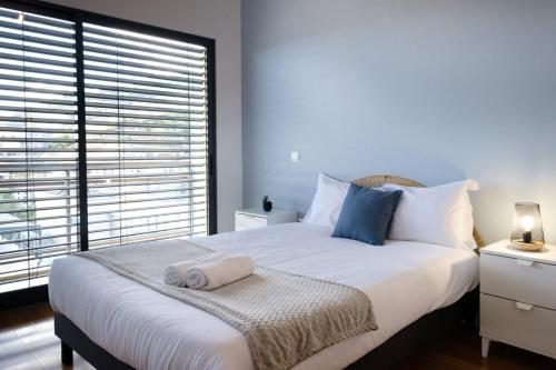 卡尼索GuestReady - Charming Caniço Retreat的卧室配有一张大白色床和窗户