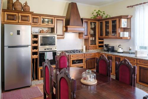 圣维森特GuestReady - Tranquil Spot in São Vicente的厨房配有木制橱柜、桌子和冰箱。