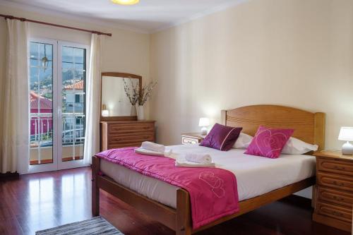 圣维森特GuestReady - Tranquil Spot in São Vicente的一间卧室配有一张带紫色枕头的大床