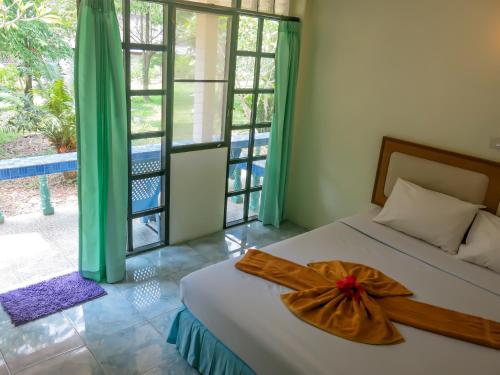 高兰海水阳光简易别墅酒店的一间卧室,配有一张床,床上有一个弓