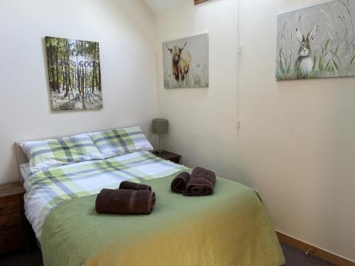 达夫敦Broomhead Cottages的一间卧室配有一张床,上面有两条毛巾