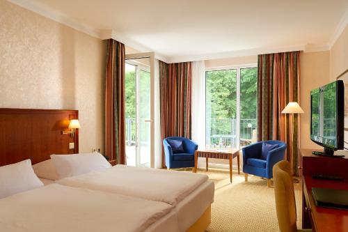 宾茨宾兹大酒店的酒店客房带一张床、一张桌子和椅子