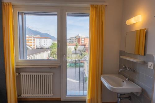洛迦诺洛迦诺青年旅舍的一间带水槽的浴室和一个美景窗户