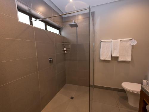 勒斯滕堡ANEW Resort Hunters Rest Rustenburg的浴室设有玻璃淋浴间和卫生间