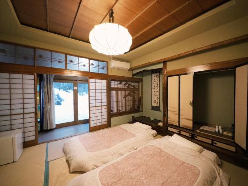 小樽小樽锦園的一间卧室设有两张床、一台电视和窗户。