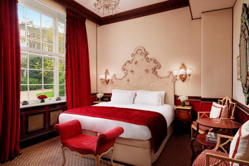 伦敦红色康乃馨蒙塔古花园酒店的酒店客房带一张床、一张桌子和椅子