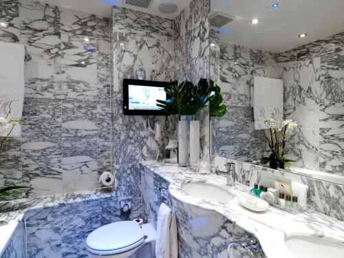 伦敦红色康乃馨蒙塔古花园酒店的一间带卫生间的浴室和墙上的电视