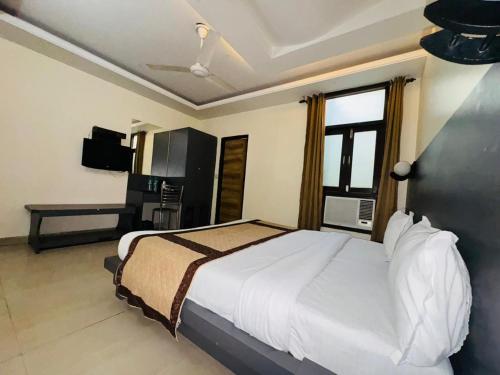 新德里Hotel Airport Stay - Near Terminal 3的一间卧室配有一张大床和电视