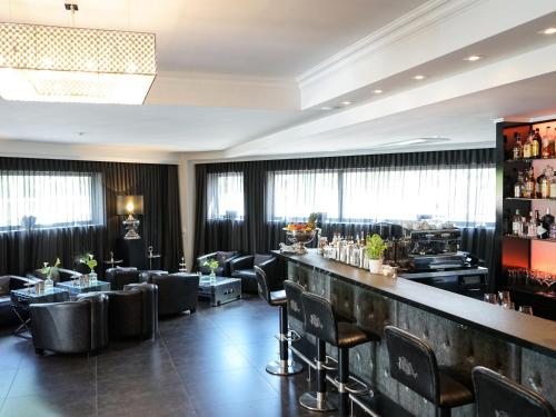 科隆莱茵布里克别墅酒店的餐厅内的酒吧配有椅子和柜台
