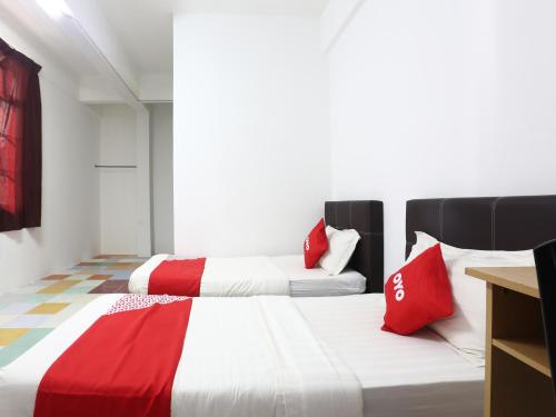 哥打巴鲁KB Rest Inn-Twin Single的红色和白色的客房内的两张床