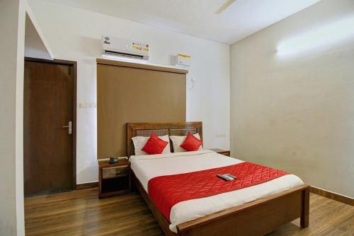 钦奈Dakshin Stays的一间卧室配有红色枕头的床