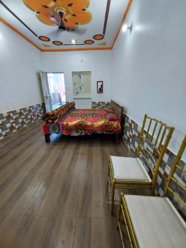 巴雷利Sanjay resort and hotel的一间设有床铺和两把椅子的房间