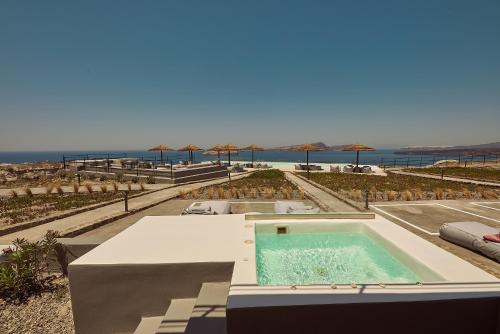 阿克罗蒂里Coco-Mat Hotel Santorini的一座带海滩的建筑的顶部游泳池