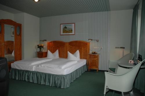 拉德博伊尔高德纳安克酒店的酒店客房带一张床、一张桌子和椅子