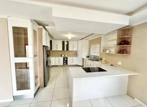 鲸湾港Coral Bliss的厨房配有白色橱柜和白色台面