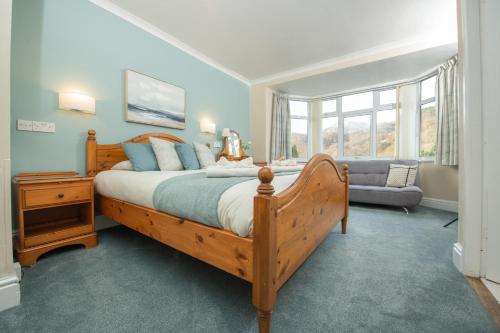 贝图瑟科伊德Tyn-y-Coed Inn的一间卧室配有一张大型木床和一张沙发