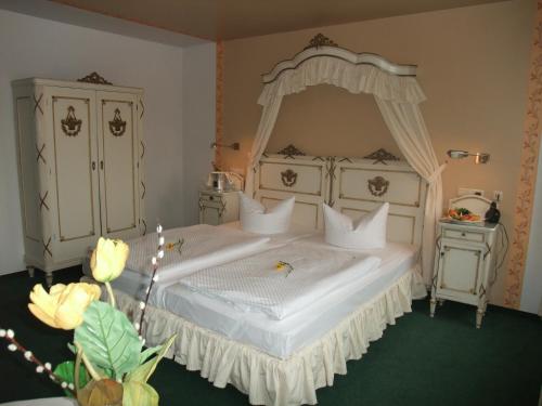 拉德博伊尔高德纳安克酒店的一间卧室配有一张带天蓬的白色床