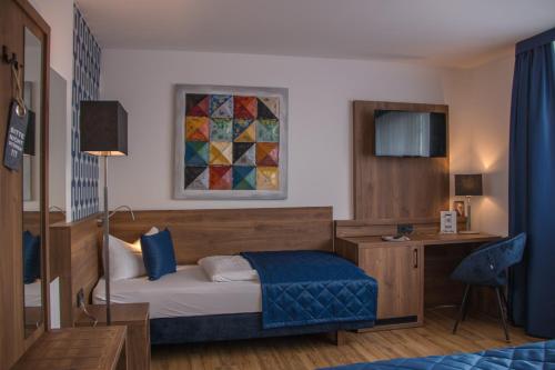 班贝格Hotel am Brauerei-Dreieck的酒店客房配有一张床、一张书桌和一张西德西德西德西德床