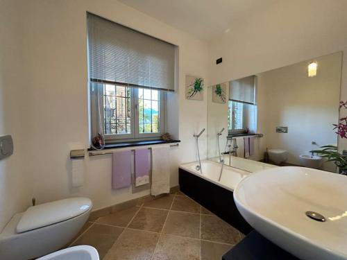 Oggebiovilla quiete的浴室配有卫生间、浴缸和水槽。