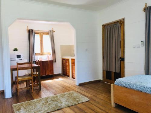Santo AntónioKingfisher- Principe的一间卧室配有一张床、一张书桌和一个窗户。