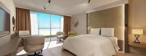 滨海韦克霍格杜茵酒店的配有一张床、一张书桌和一扇窗户的酒店客房