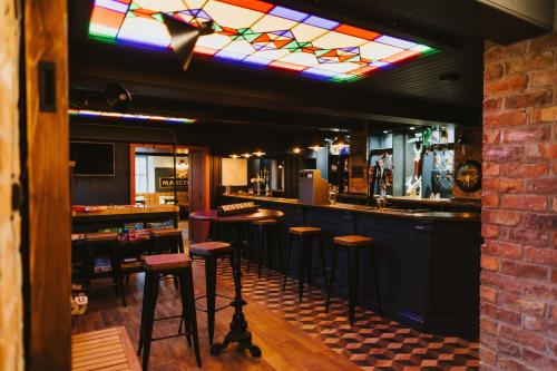 布里格The White Hart的酒吧设有凳子和彩色玻璃天花板
