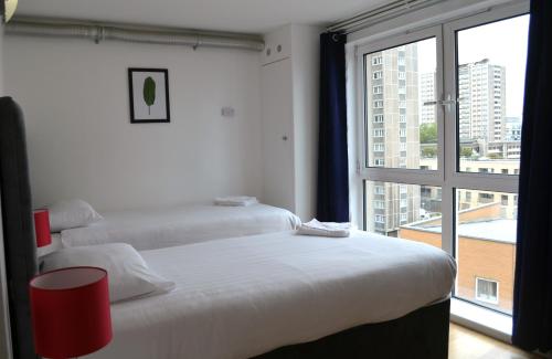 伦敦进入城市公寓的带大窗户的客房内的两张床
