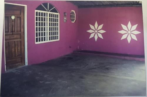 San MiguelitoBetohouse的墙上有粉红色的墙壁,墙上挂着鲜花