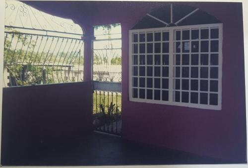 San MiguelitoBetohouse的紫色的门,带窗户和栅栏