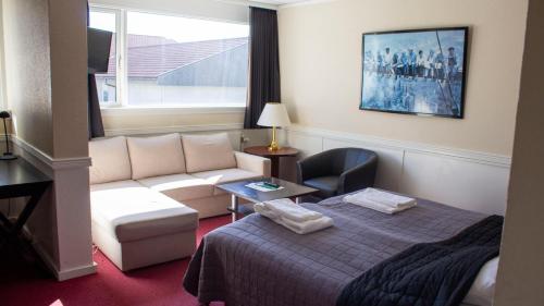 海泽胡瑟讷A Hotels Roskilde的酒店客房,配有床和沙发