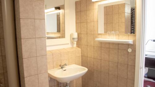 海泽胡瑟讷A Hotels Roskilde的一间带水槽和镜子的浴室