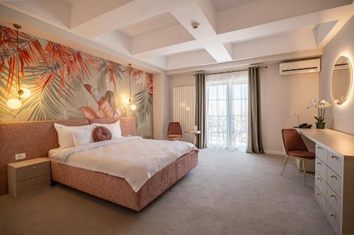 马马亚Hotel Ges的卧室配有一张大床,墙上挂有绘画作品