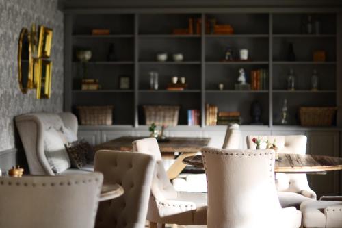 KungsängenGällöfsta Konferens & Herrgård的一间用餐室,配有白色的椅子、桌子和书架