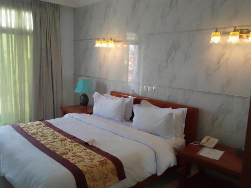 杜阿拉GRAND HOTEL CITY, Douala的酒店客房配有一张带白色枕头的大床