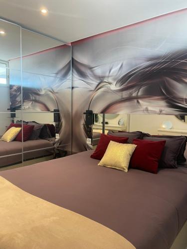 阿格德角Village Naturiste - Xcape Sea View Luxe的一间卧室配有一张带红色枕头的大床