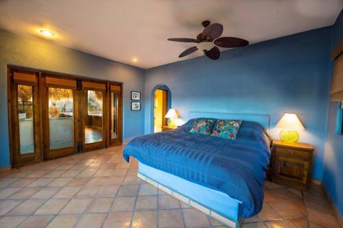 洛雷托Casa de Vista Hermosa的蓝色卧室配有床和吊扇